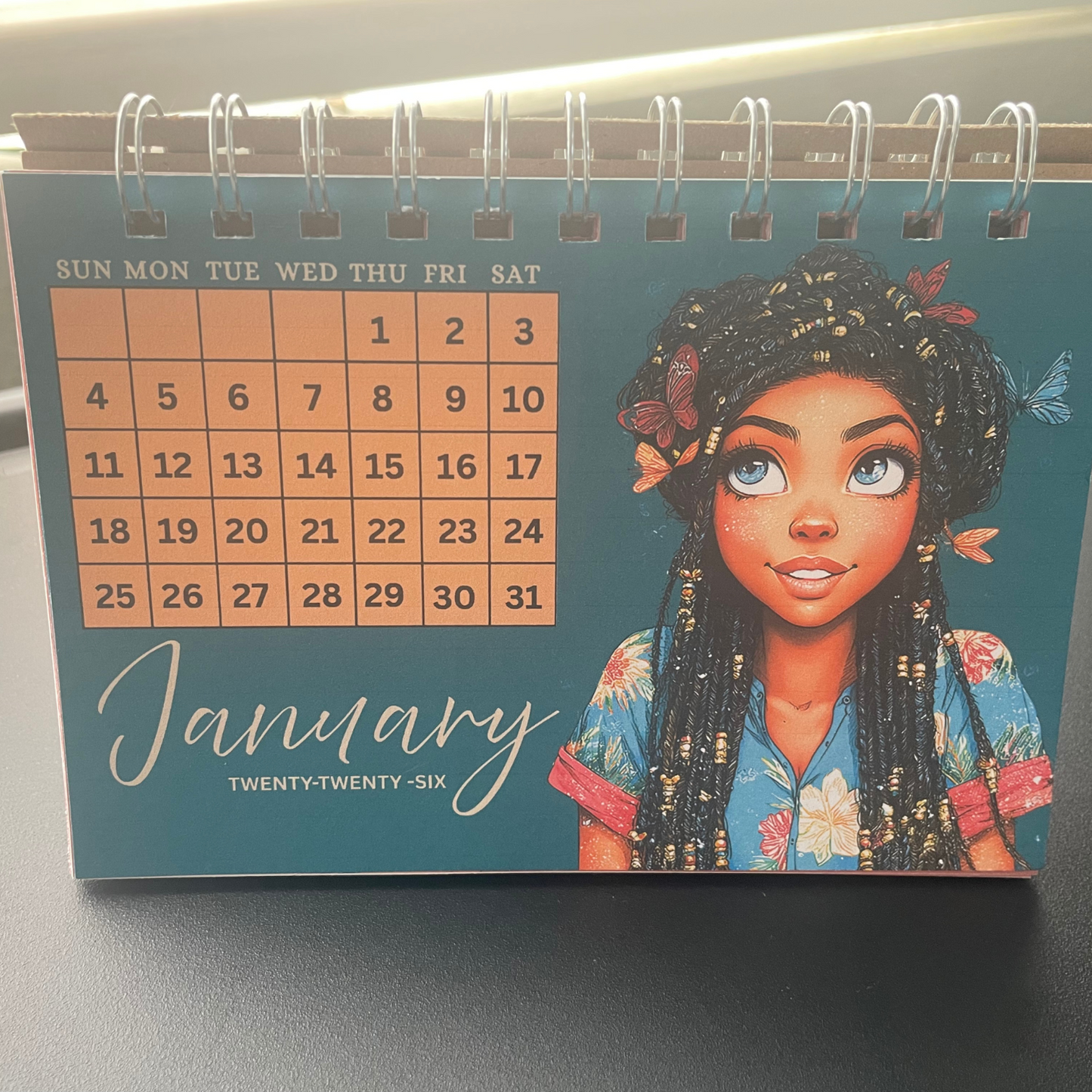 Calendar with an illustration of a woman on the cover, showing January 2026.